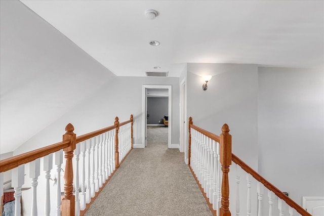 corridor featuring light colored carpet and vaulted ceiling