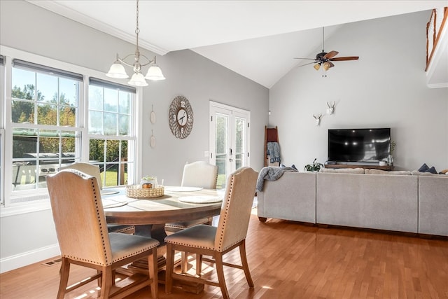 dining space with french doors, ceiling fan with notable chandelier, vaulted ceiling, and hardwood / wood-style flooring