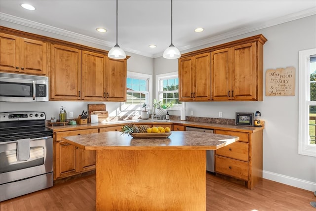 kitchen featuring decorative light fixtures, hardwood / wood-style flooring, stainless steel appliances, and a center island