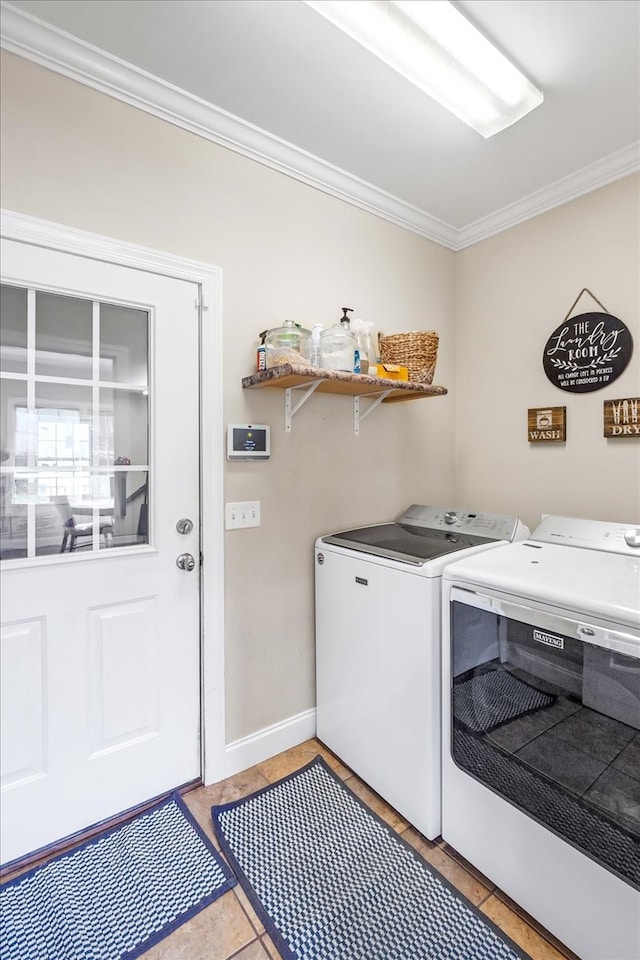 laundry area with ornamental molding, light tile patterned flooring, and washer and dryer