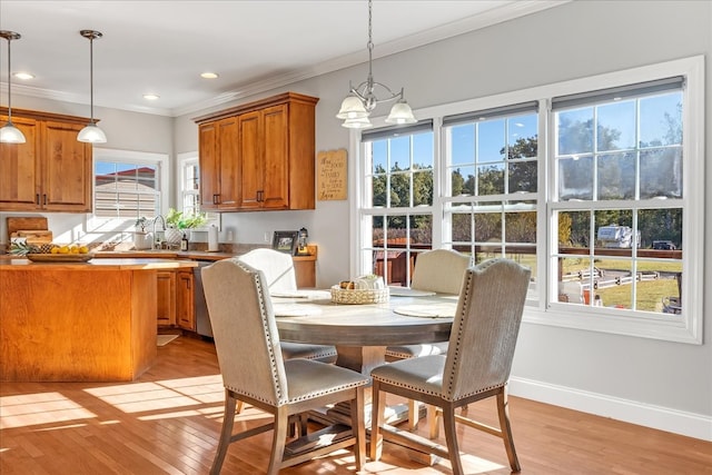 dining space with crown molding, plenty of natural light, and light hardwood / wood-style floors