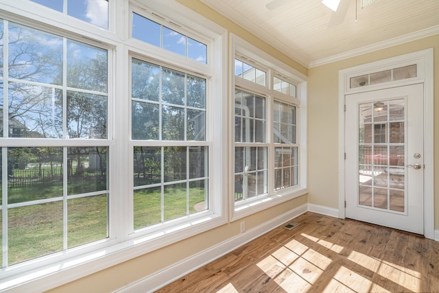 unfurnished sunroom featuring ceiling fan