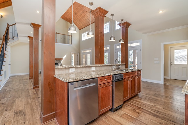 kitchen with light hardwood / wood-style flooring, hanging light fixtures, sink, and stainless steel dishwasher