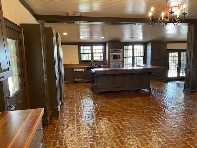 kitchen featuring plenty of natural light, wooden counters, a center island, and double oven