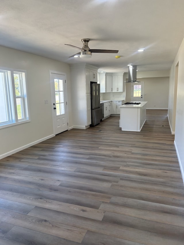 kitchen featuring exhaust hood, stainless steel fridge, plenty of natural light, white cabinetry, and dark hardwood / wood-style flooring