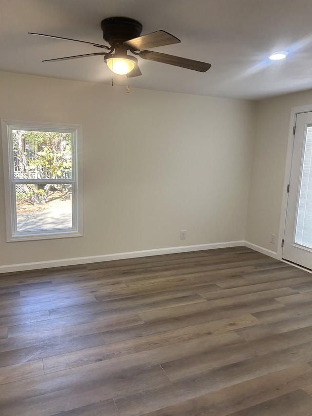 empty room with ceiling fan and dark hardwood / wood-style flooring