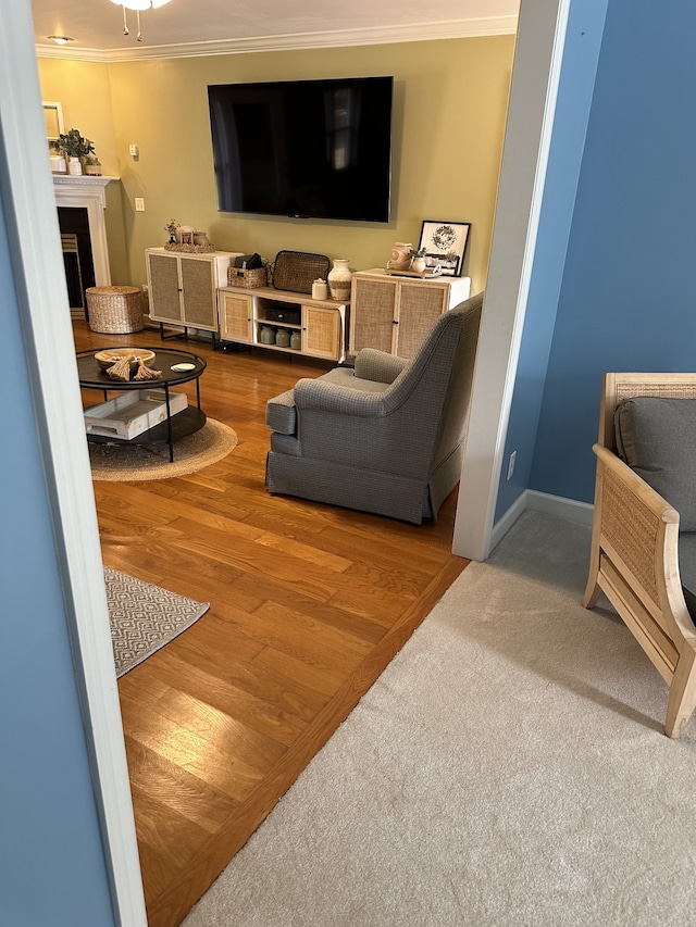 living room featuring wood-type flooring, crown molding, and ceiling fan