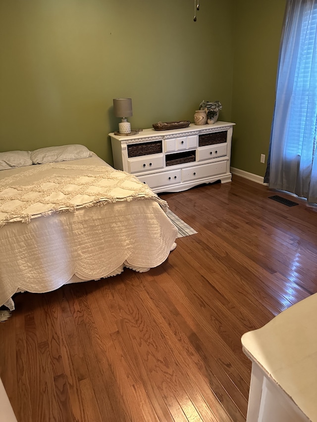 bedroom with dark hardwood / wood-style floors