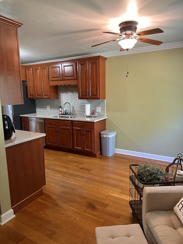 kitchen featuring light wood-type flooring, crown molding, decorative backsplash, and sink