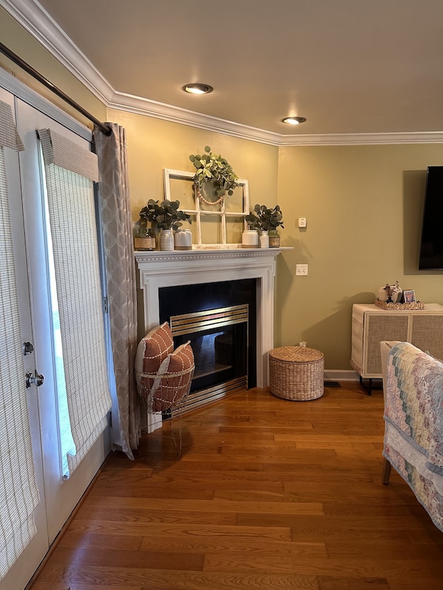 sitting room with ornamental molding and hardwood / wood-style flooring