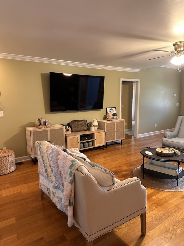 living room featuring crown molding, ceiling fan, and light hardwood / wood-style floors