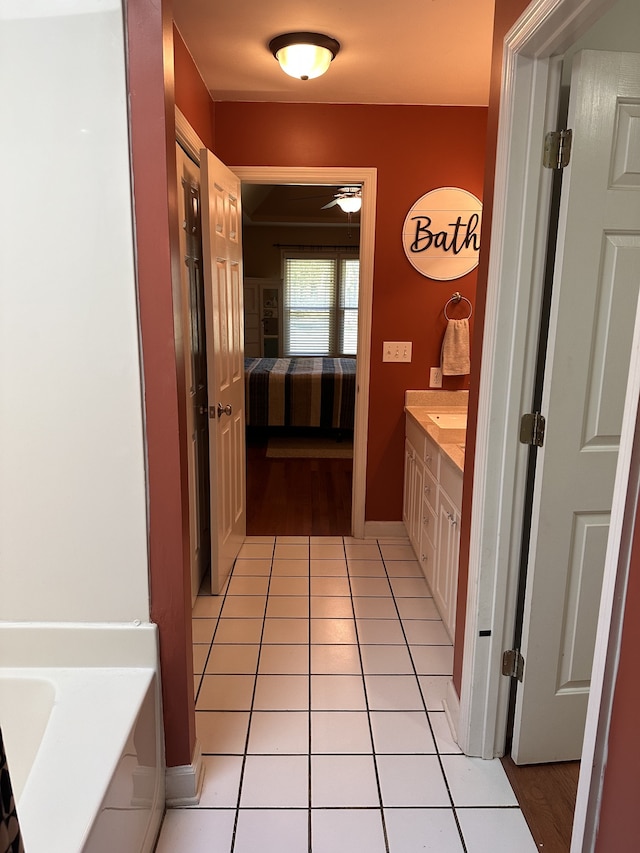 bathroom with ceiling fan, a bathing tub, tile patterned flooring, and vanity