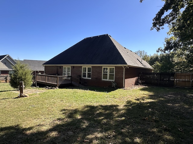 rear view of house with a lawn and a deck