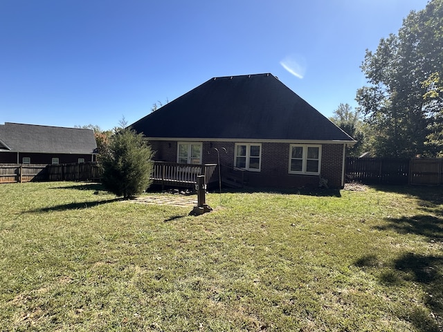 back of property featuring a deck and a yard