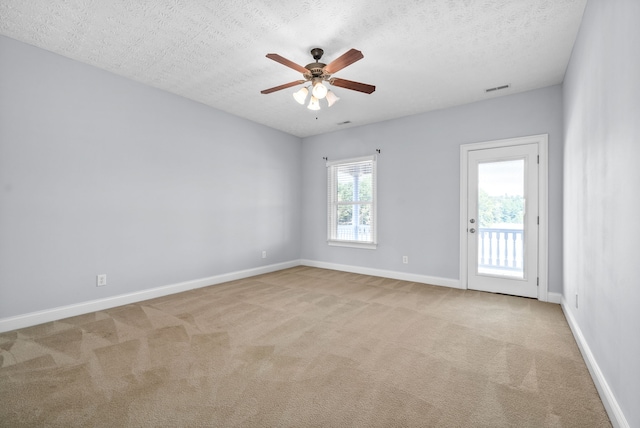 carpeted spare room featuring ceiling fan and a textured ceiling