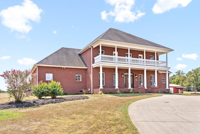 view of front of home featuring a porch, a balcony, and a front lawn