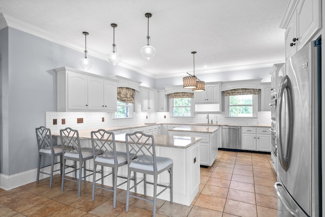 kitchen featuring kitchen peninsula, crown molding, white cabinets, and appliances with stainless steel finishes