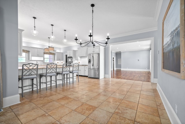 kitchen featuring ornamental molding, tasteful backsplash, white cabinetry, stainless steel appliances, and a kitchen breakfast bar