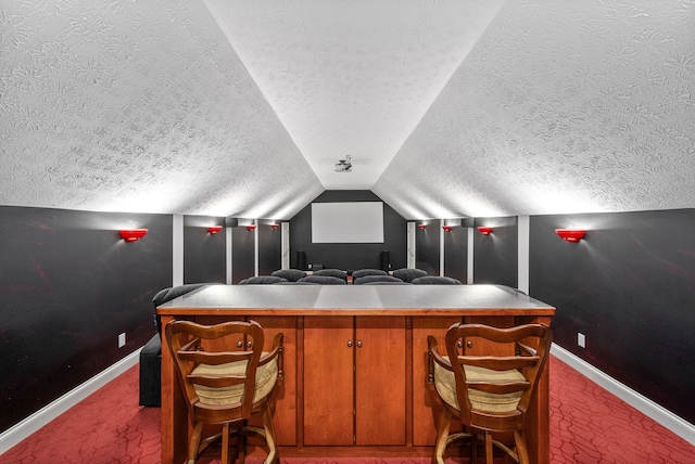 cinema featuring carpet floors, a textured ceiling, and vaulted ceiling