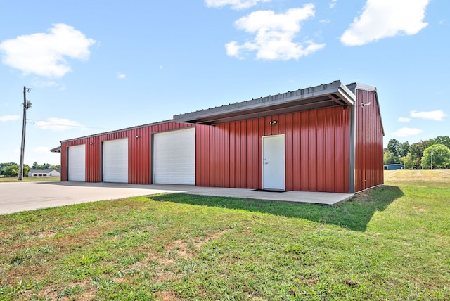 view of outdoor structure with a garage and a lawn