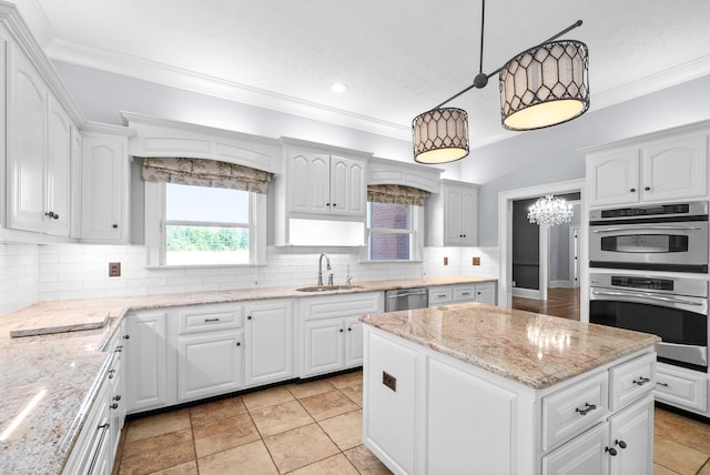 kitchen featuring white cabinets, appliances with stainless steel finishes, hanging light fixtures, and sink