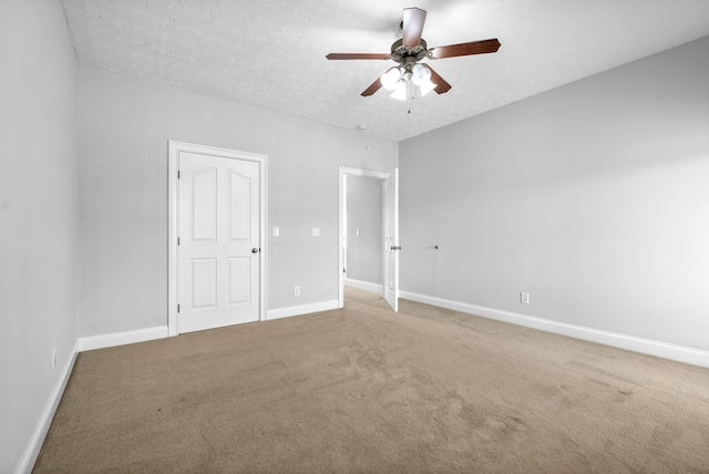 carpeted spare room featuring ceiling fan and a textured ceiling