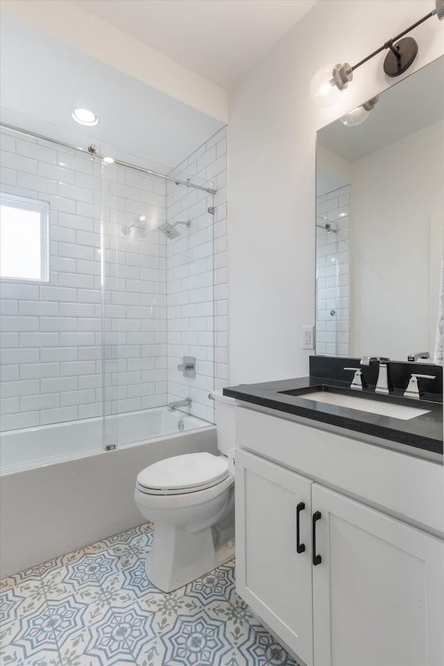 full bathroom featuring tile patterned floors, toilet, vanity, and tiled shower / bath combo