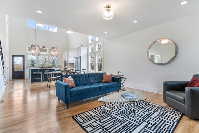 living room with light hardwood / wood-style flooring and a high ceiling