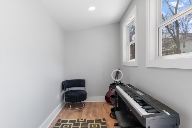 misc room featuring wood-type flooring, heating unit, and vaulted ceiling