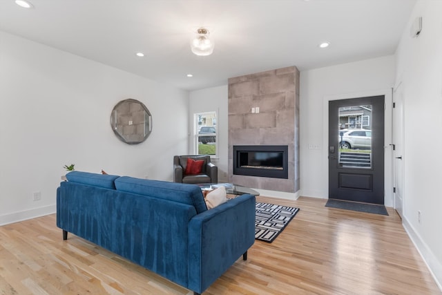 living room featuring light hardwood / wood-style floors and a tile fireplace