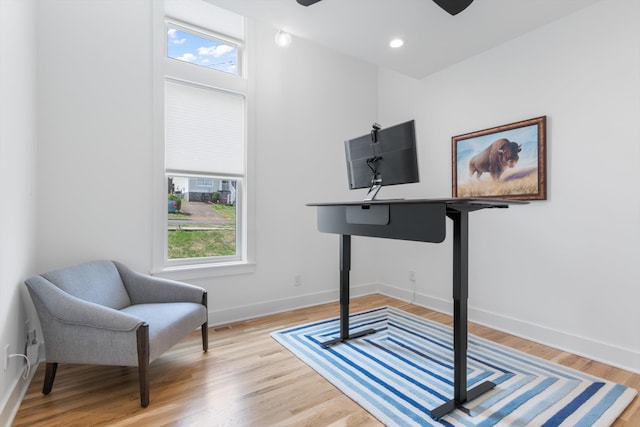 living area with ceiling fan, light hardwood / wood-style flooring, and a healthy amount of sunlight