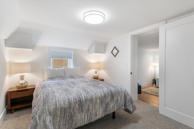 bedroom with vaulted ceiling and carpet flooring