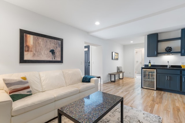 living room with wine cooler, light wood-type flooring, and wet bar