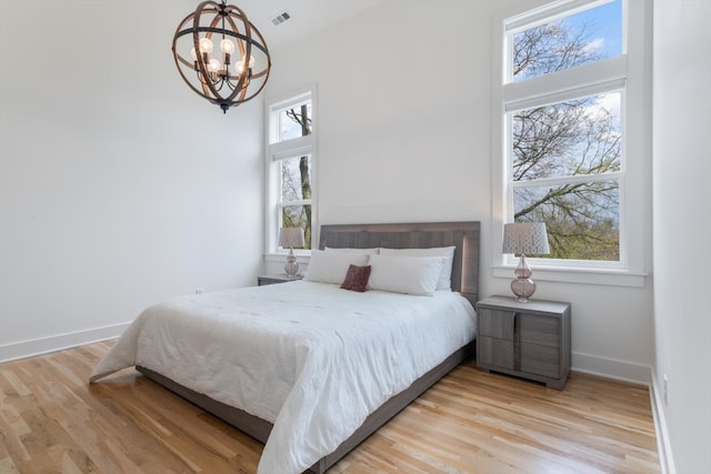 bedroom with light hardwood / wood-style flooring and multiple windows