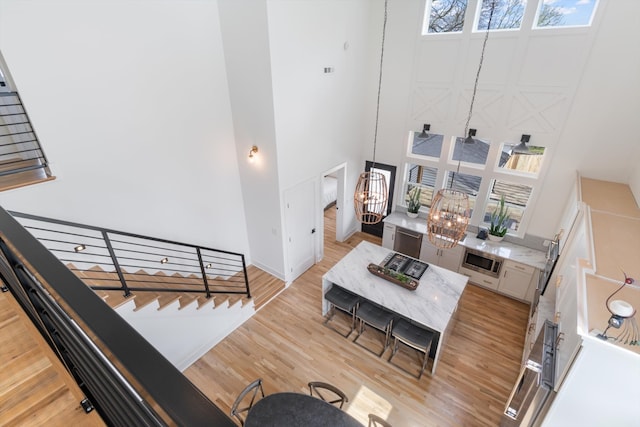 living room featuring light wood-type flooring and a high ceiling