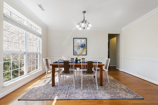 dining room featuring plenty of natural light, ornamental molding, and hardwood / wood-style floors