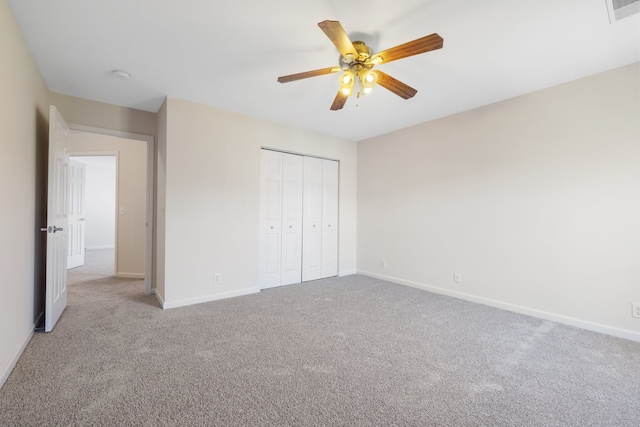 unfurnished bedroom with ceiling fan, light colored carpet, and a closet