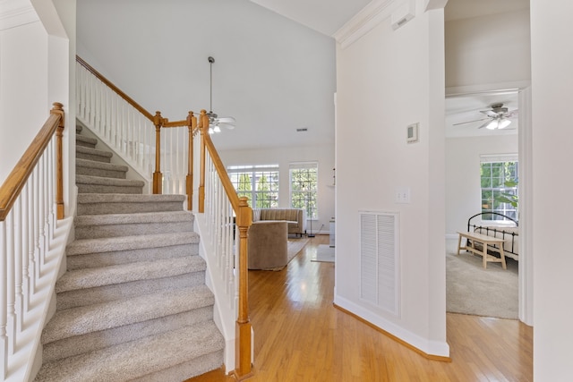 staircase with hardwood / wood-style flooring, ornamental molding, and a wealth of natural light