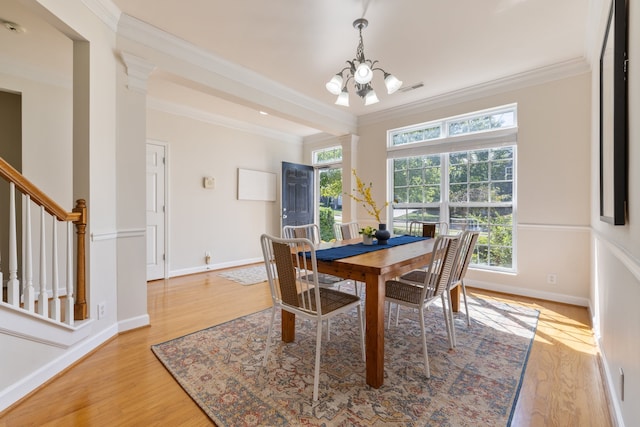 dining area with light wood-type flooring, ornamental molding, and a wealth of natural light