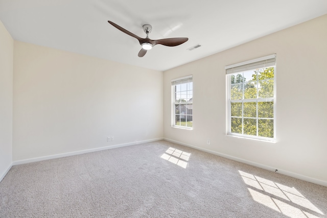 carpeted spare room featuring ceiling fan