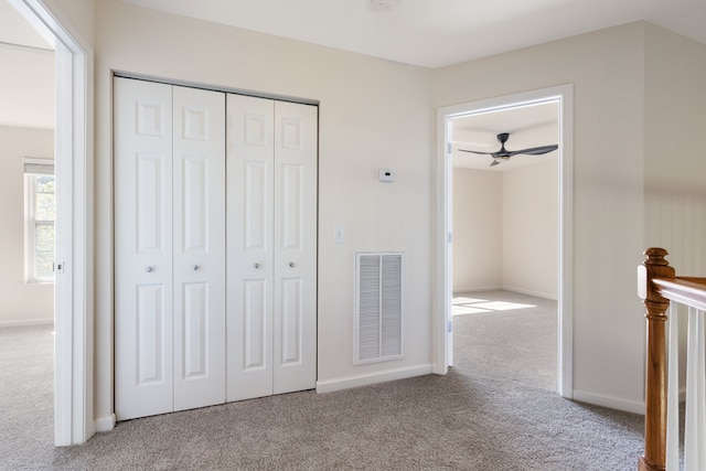 unfurnished bedroom with a closet and light colored carpet