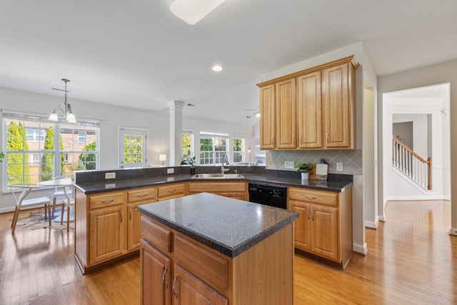 kitchen with sink, kitchen peninsula, light hardwood / wood-style flooring, a center island, and black dishwasher