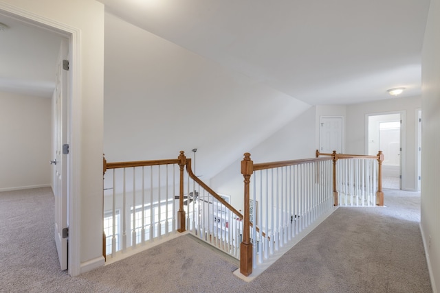 hall with light carpet and vaulted ceiling