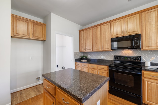 kitchen featuring tasteful backsplash, a center island, black appliances, and light wood-type flooring