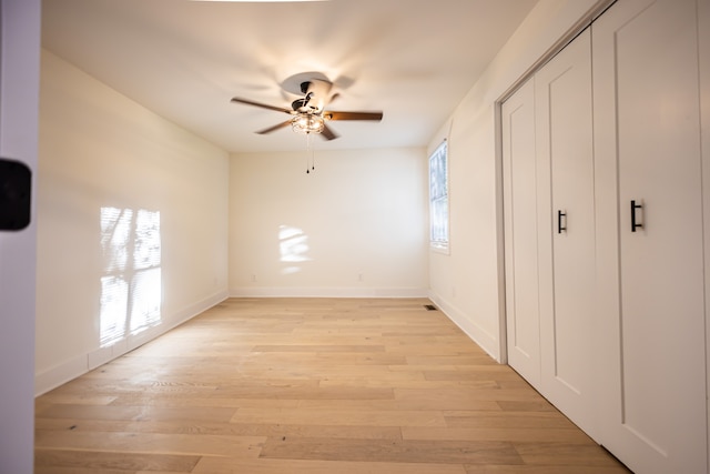 unfurnished bedroom featuring light hardwood / wood-style flooring, multiple windows, and ceiling fan