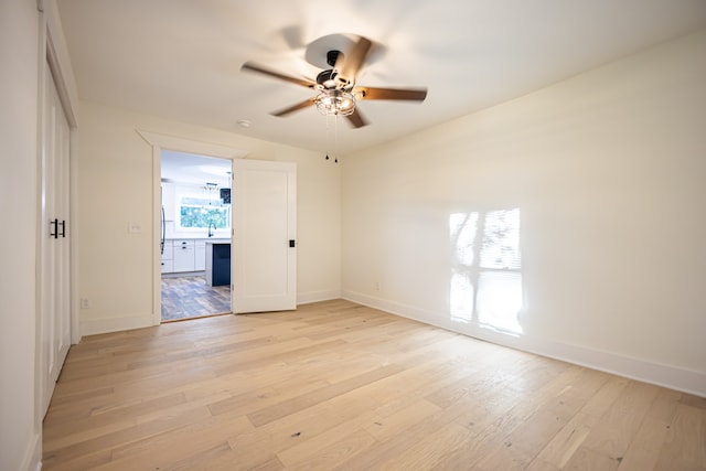 unfurnished room with ceiling fan, sink, and light hardwood / wood-style flooring