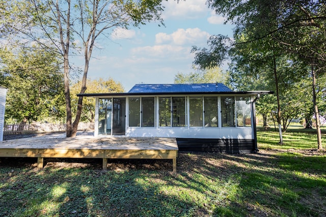 back of property featuring a sunroom and a deck