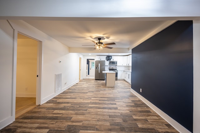 kitchen with ceiling fan, a center island, dark wood-type flooring, white cabinets, and appliances with stainless steel finishes