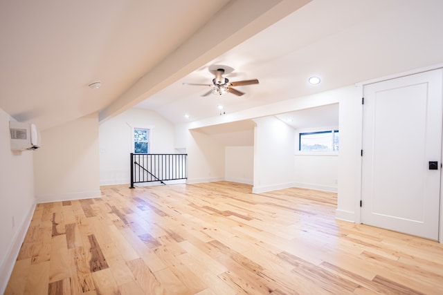 bonus room featuring a wall mounted air conditioner, light wood-type flooring, lofted ceiling with beams, and ceiling fan