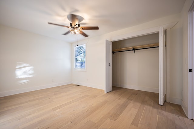 unfurnished bedroom with ceiling fan, light hardwood / wood-style floors, and a closet